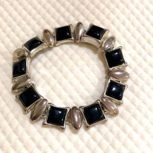 Bracelet of faux black onyx cabochons and silver metal that makes a statement